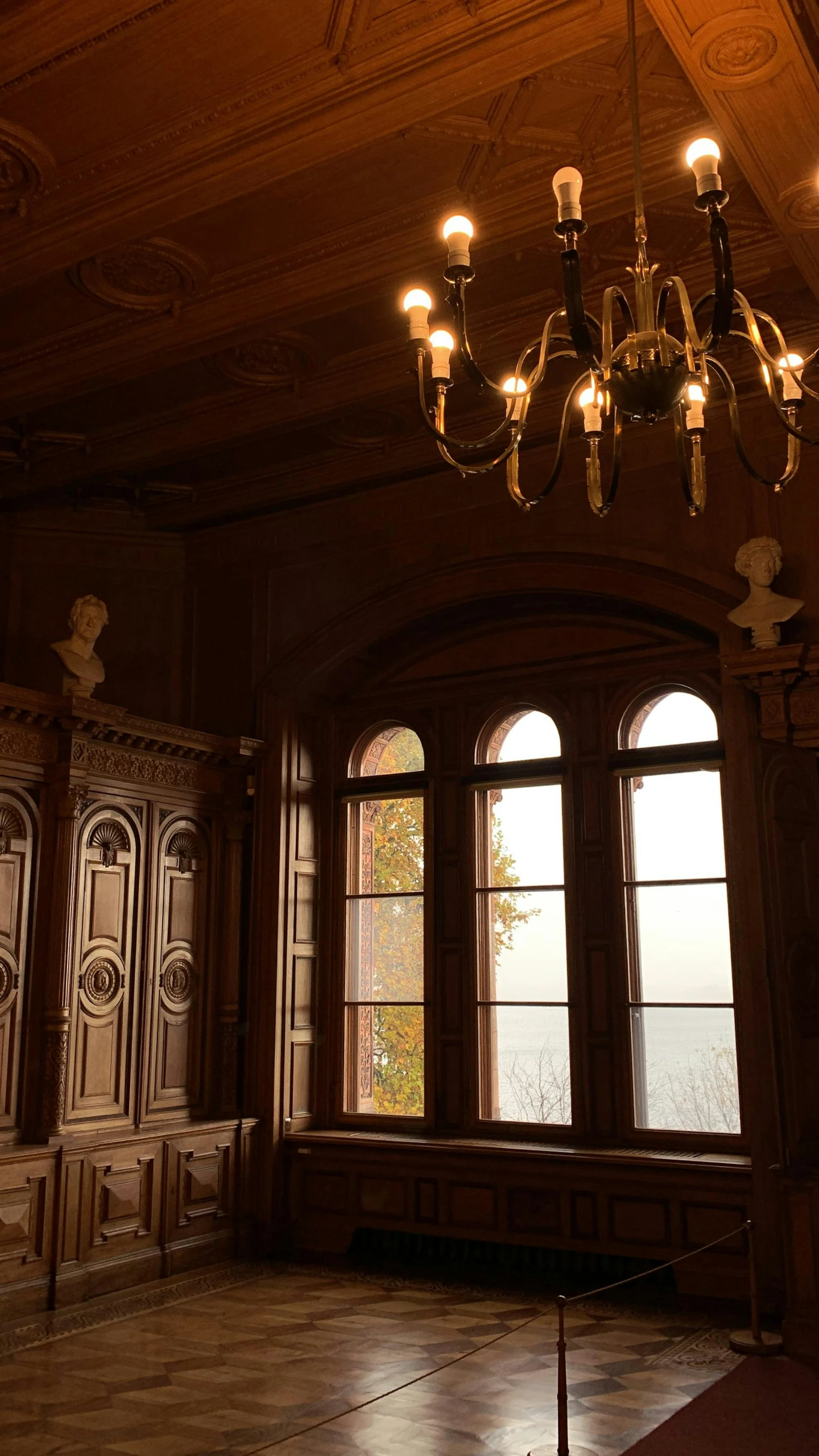 a dimly lit room features large arched windows