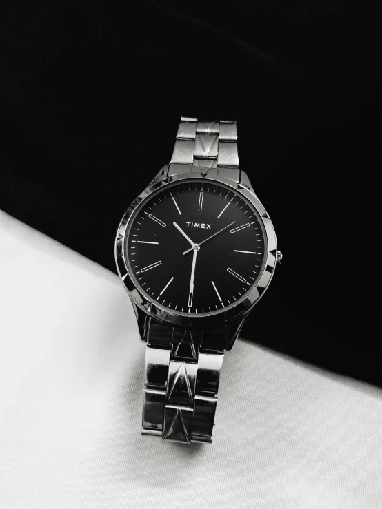 a watch sits on a table with its black dial