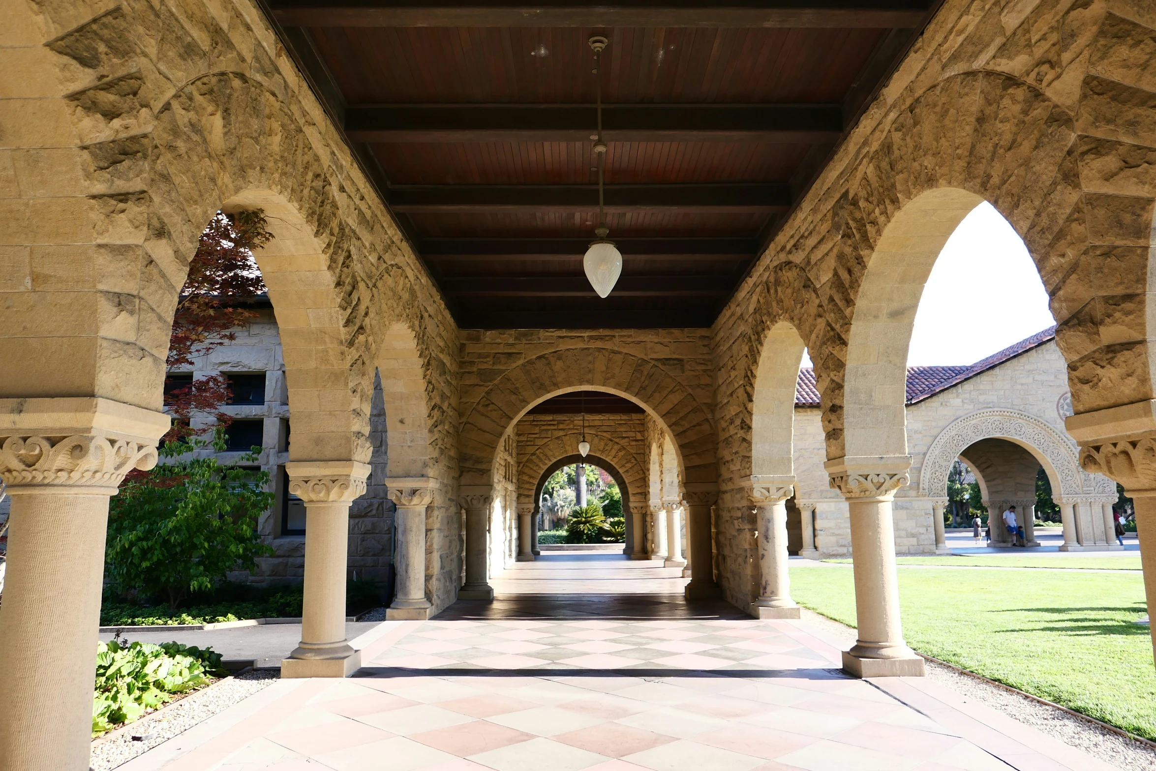 a walkway lined with arches and pillars in a park