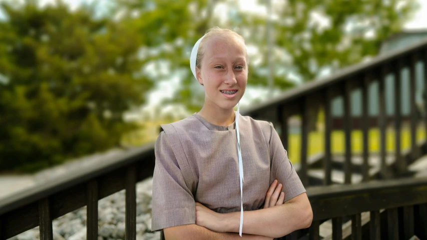 a boy standing with a wii remote by a bridge