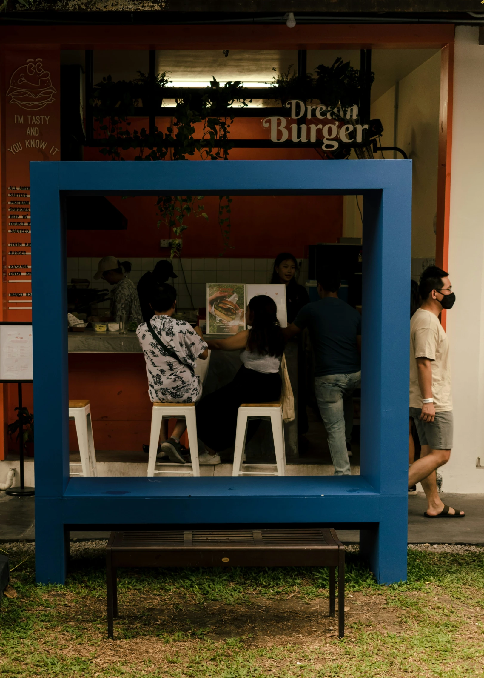 three people are sitting at small tables in a small building