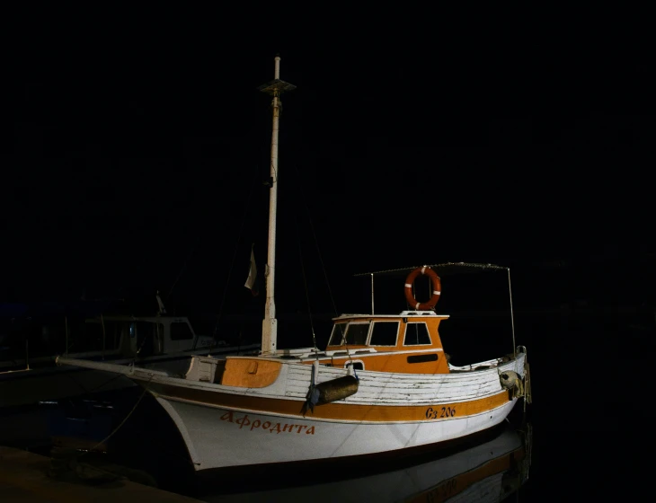 a white boat in the dark water by itself