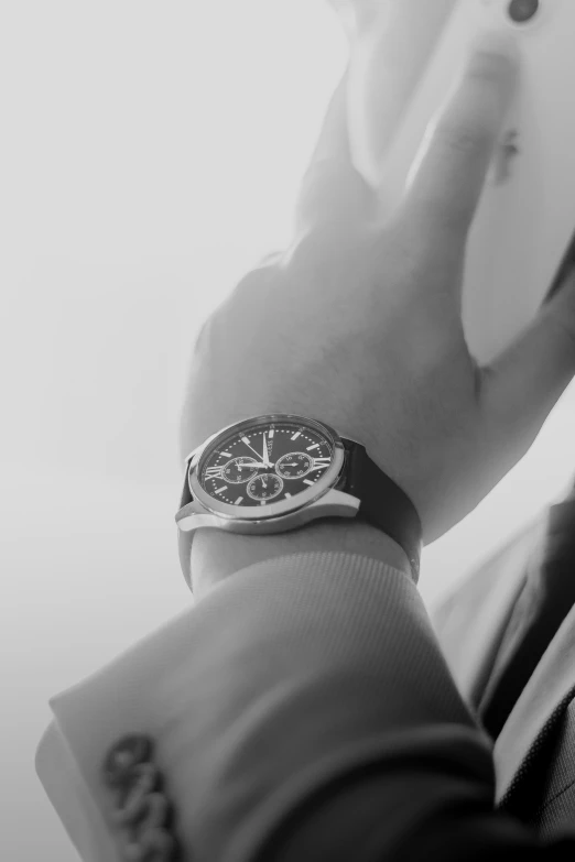 a person in a suit looking at soing on their wrist