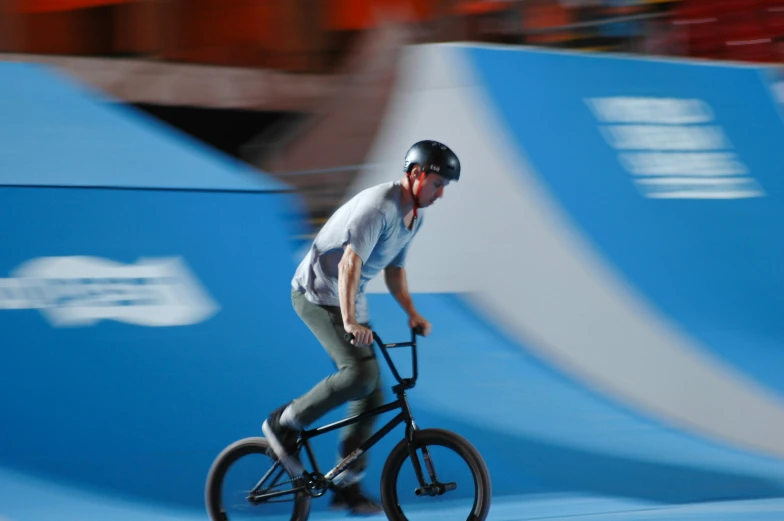 a man riding a bike on a blue floor