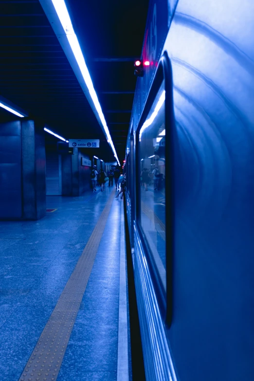 the view of a blue subway on the tracks