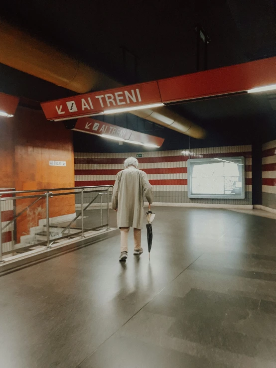 a man walking in a dark building in a large open area