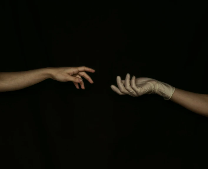 one person's hand reaching out towards another holding soing