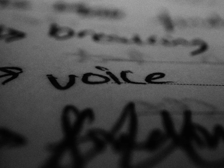 the word vote written in black ink on a white paper