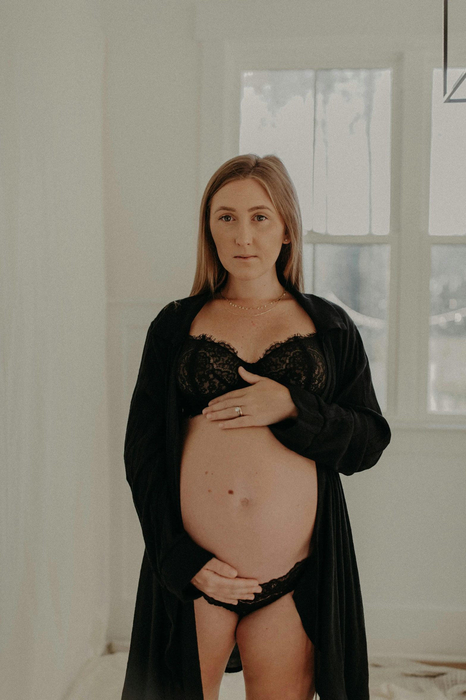 a pregnant woman in her underwear standing in a room