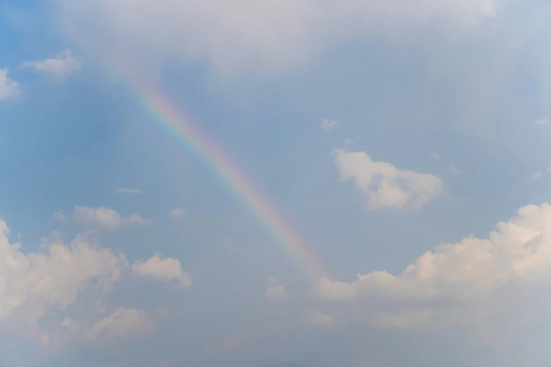 the sky is filled with clouds, and a bright rainbow can be seen