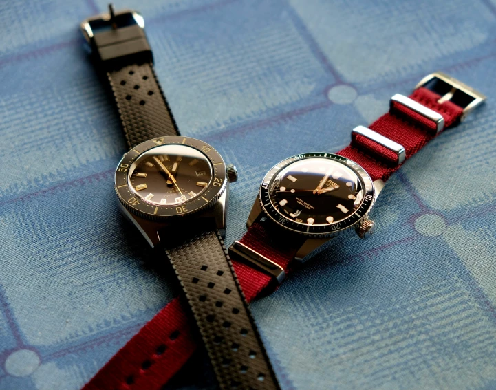 two wrist watches are sitting together on a table