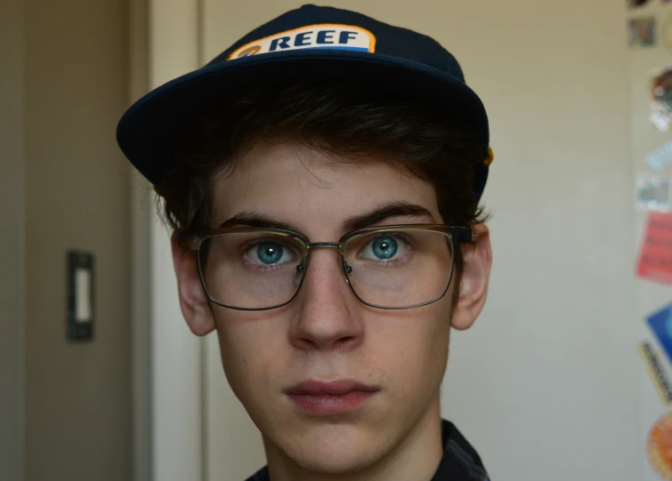 a guy wearing glasses and a hat in a room