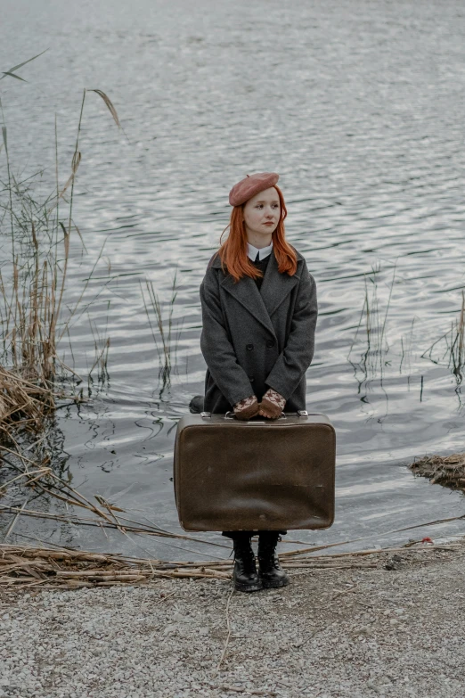 a woman with red hair sitting on a suitcase