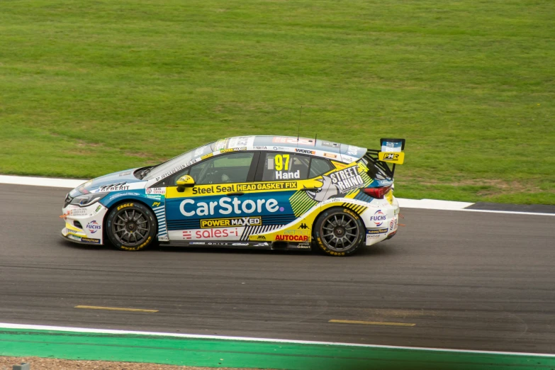 a rally car racing around a track, on grass