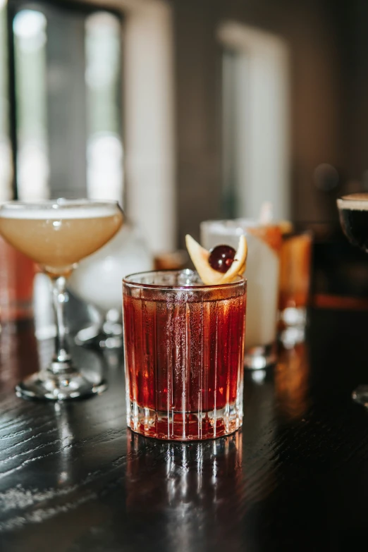 two glasses with different drinks are sitting on a table