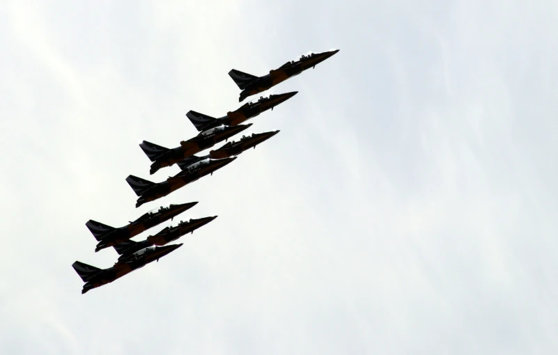 a military plane flying thru the sky with five jets