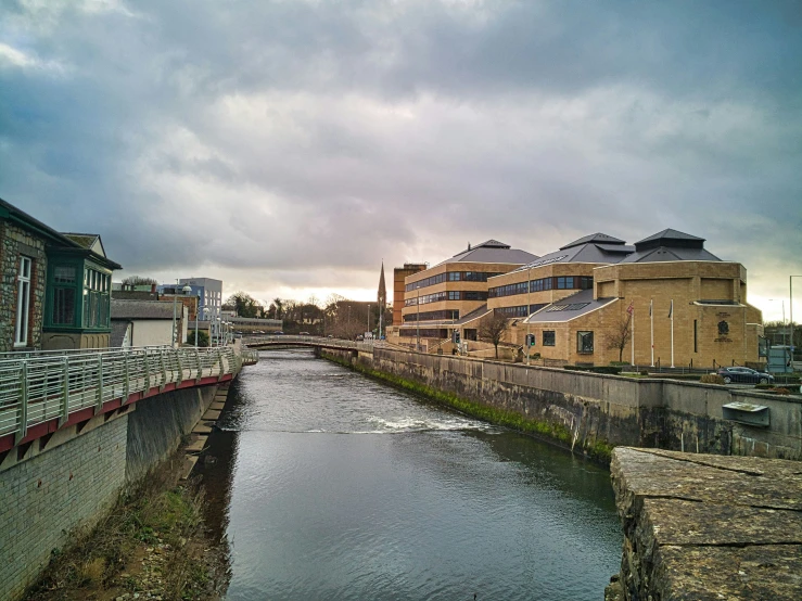 a city street next to the water with a bridge over it