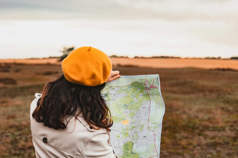 young woman looking at a map in the field