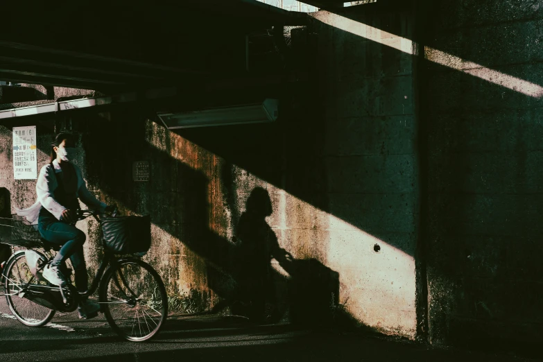 a man and woman are riding bikes under the bridge