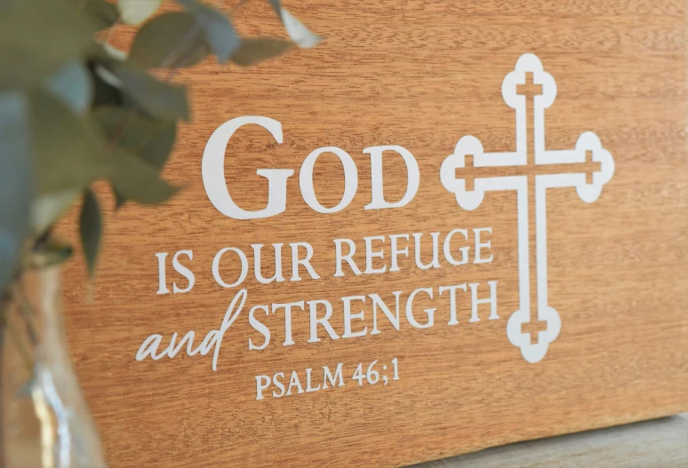 a wooden sign with a cross and lettering