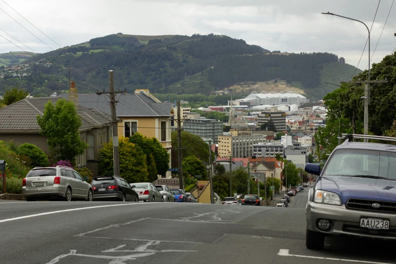 cars parked along the side of the road in front of some houses