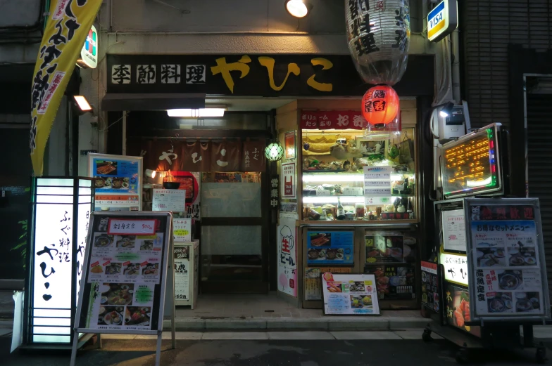 a convenience store at night lit up with advertising