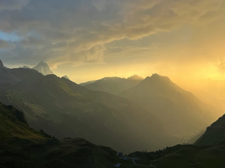 view of clouds hovering in the distance above a valley and mountains