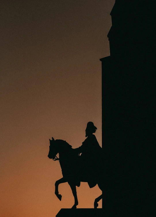 the silhouette of a statue of a person riding a horse