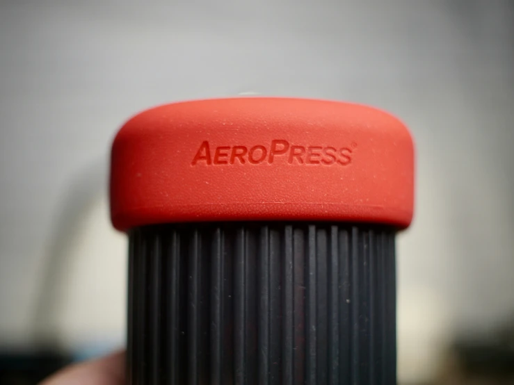 a red cap on top of an object that is aeropress