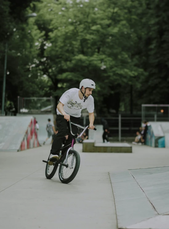 a boy is riding his bike at a skate park