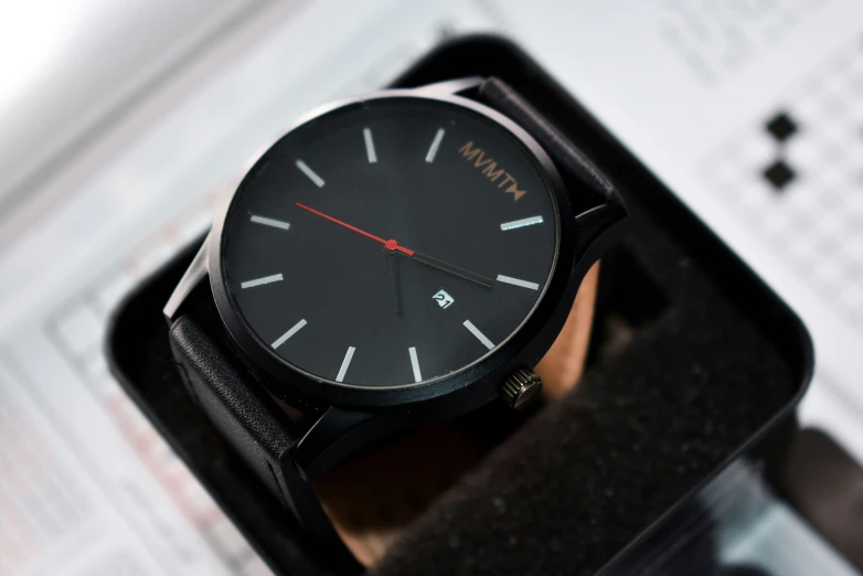 a man's wrist watch sitting on top of an empty box