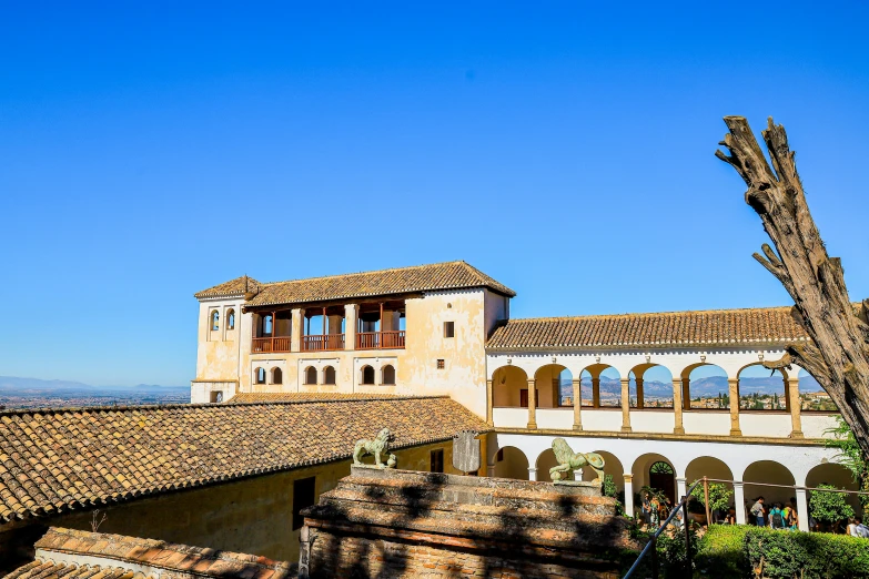 an old, large building has two tall cactus trees