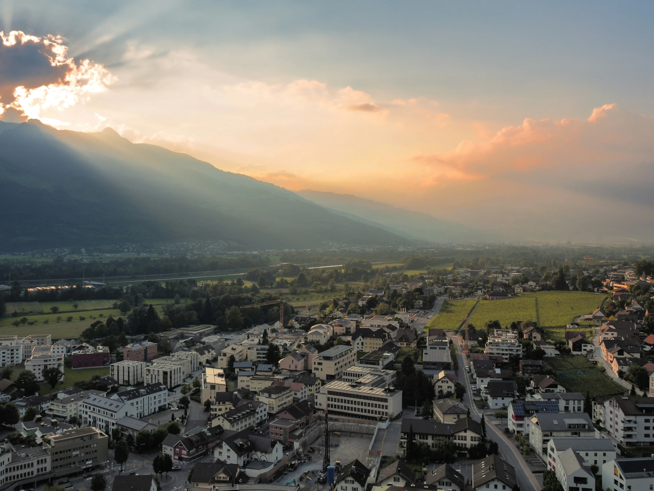 a view of a city in a rural area under a sunset sky