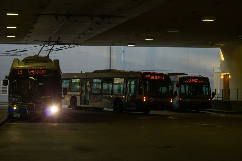 three buses are parked in the parking garage