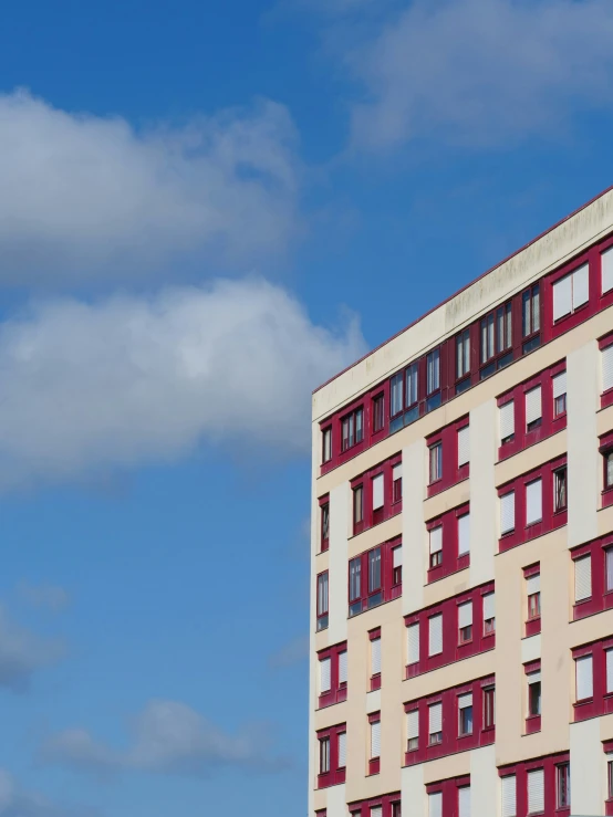 an old building with several windows that are red and white