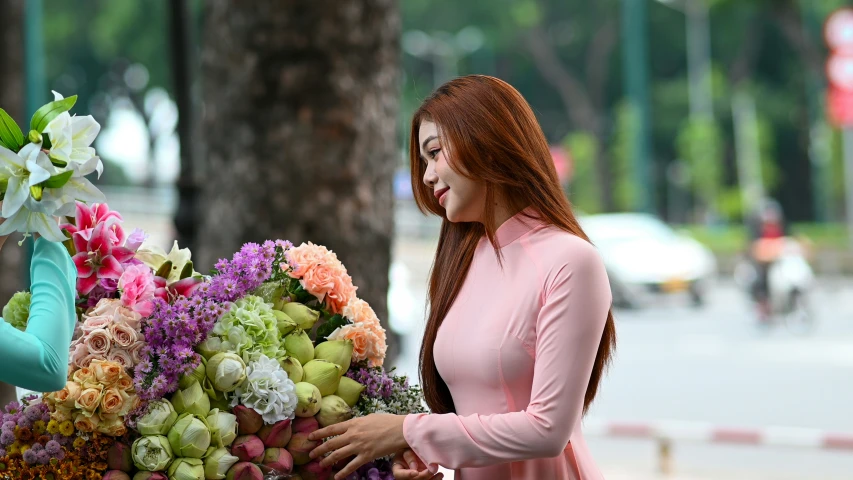 a woman looks at some flowers while holding it