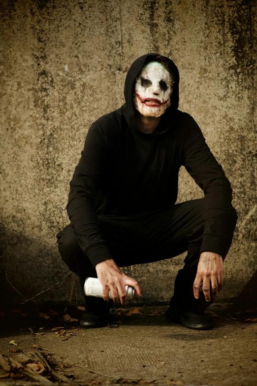 a guy in a black outfit with the makeup of the mask