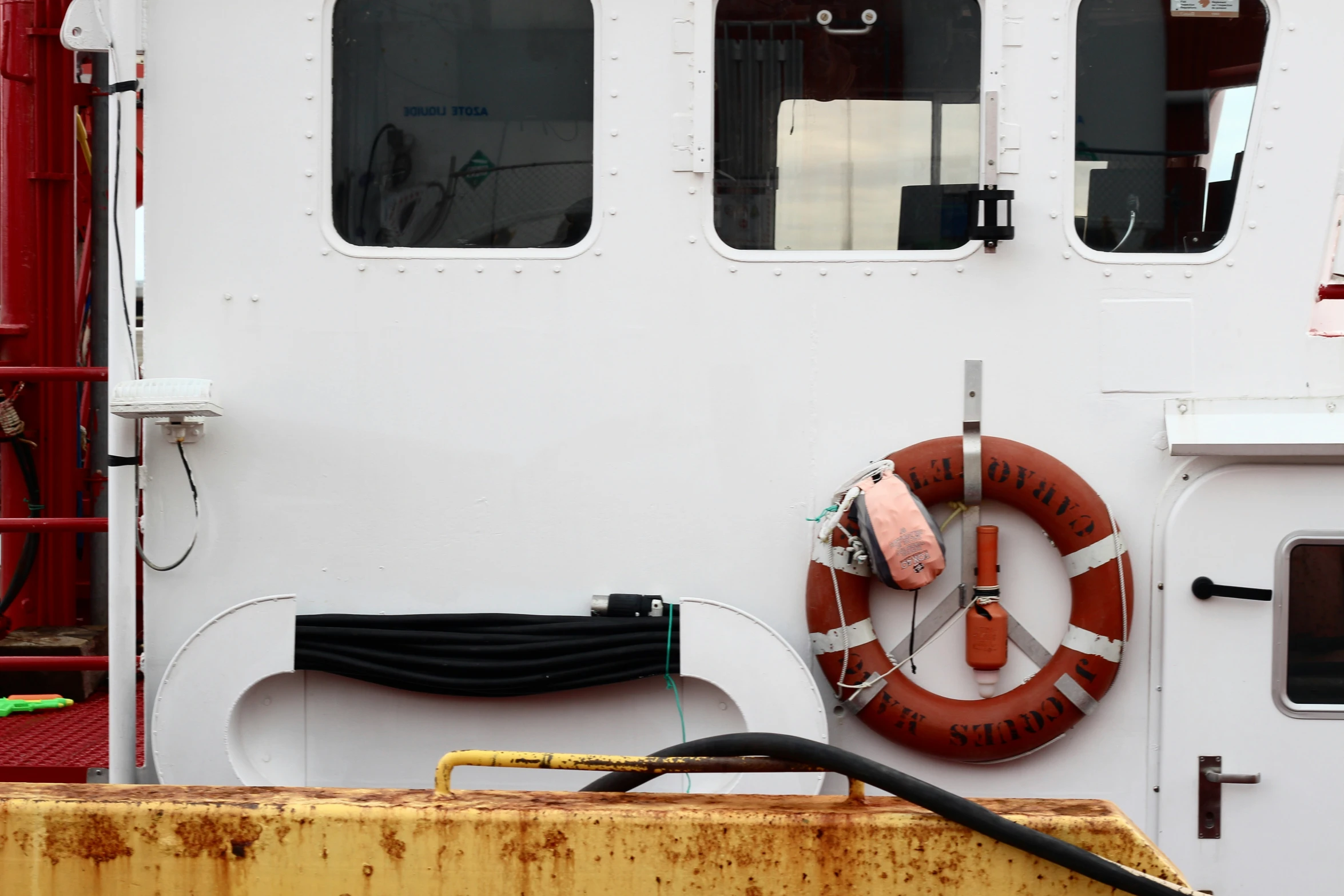 the front of a white boat, with two life preservers on each side