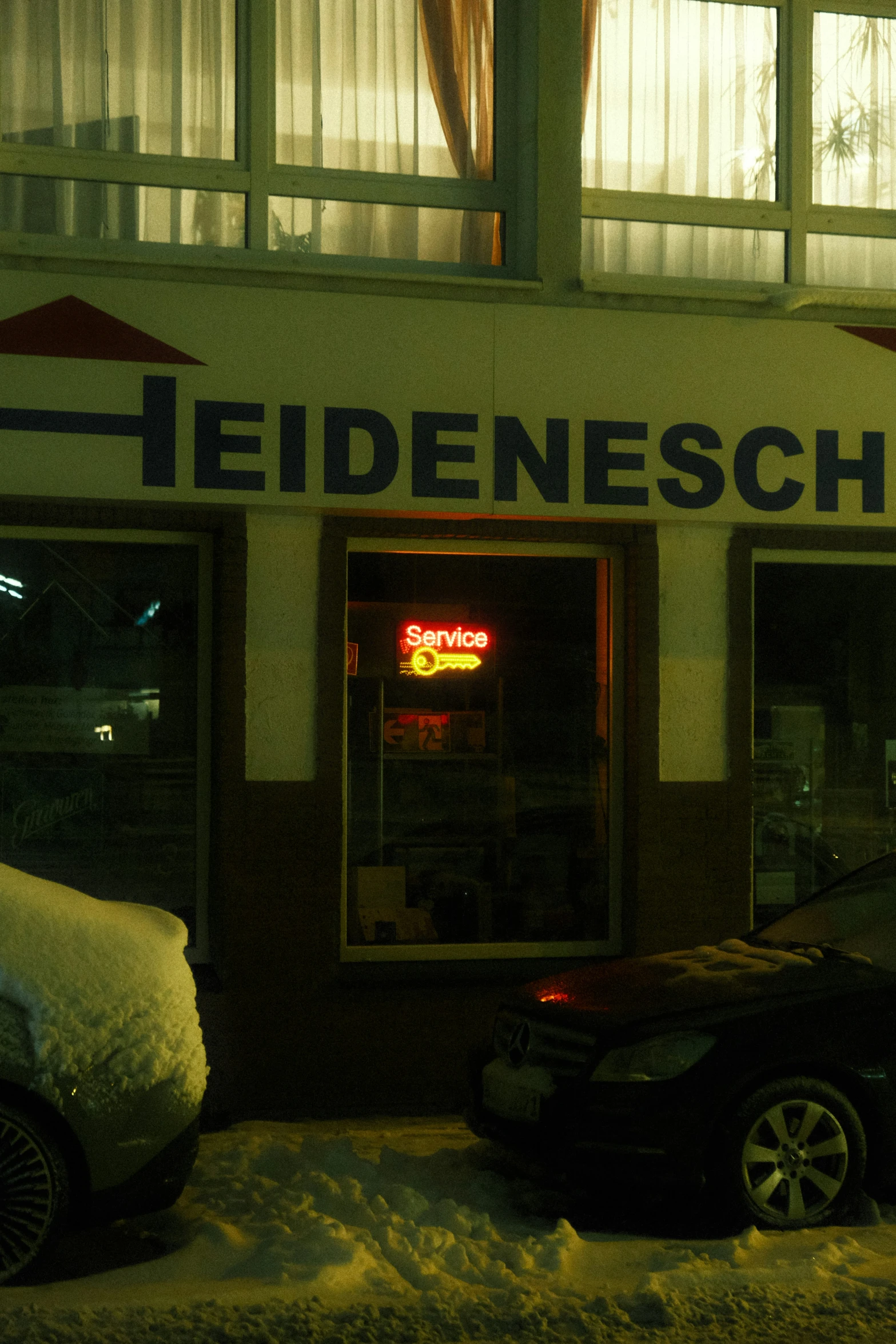 a car is parked outside a dark restaurant in the snow