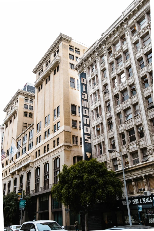 a tall building sitting next to two buildings in the middle of a road