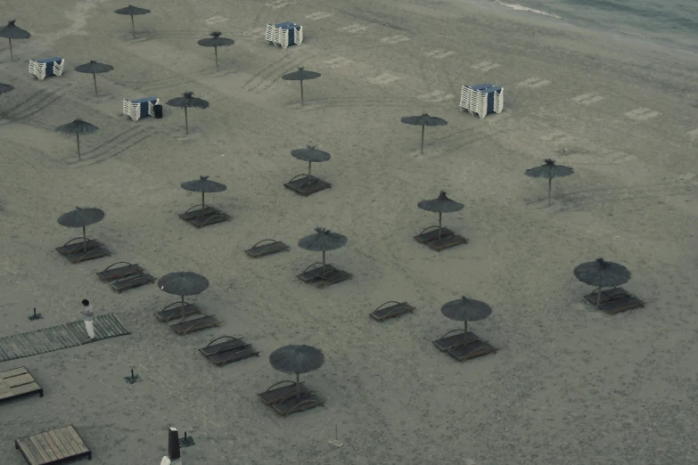 a beach filled with lots of empty umbrellas and chairs