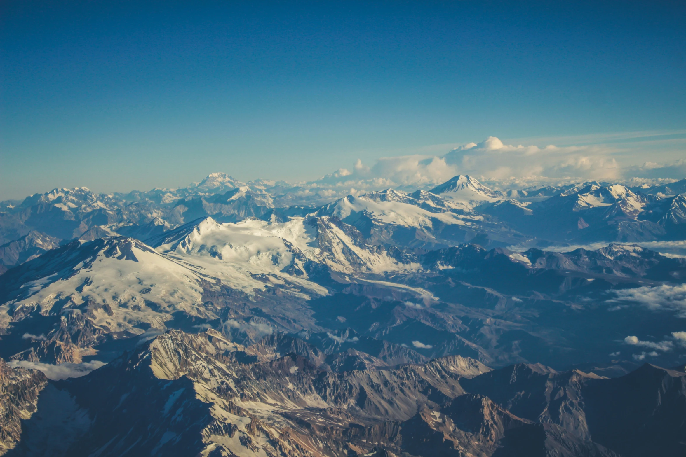 mountains seen from an airplane with a clear blue sky