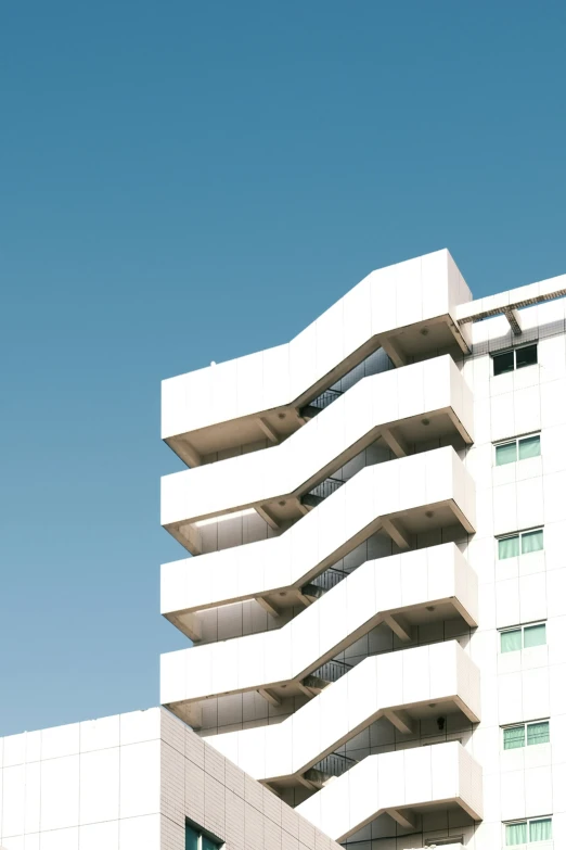 a large white building with several balconies on each floor