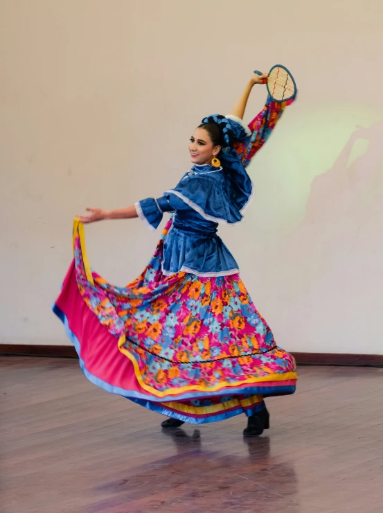 a woman in a bright dress holds a tennis racket