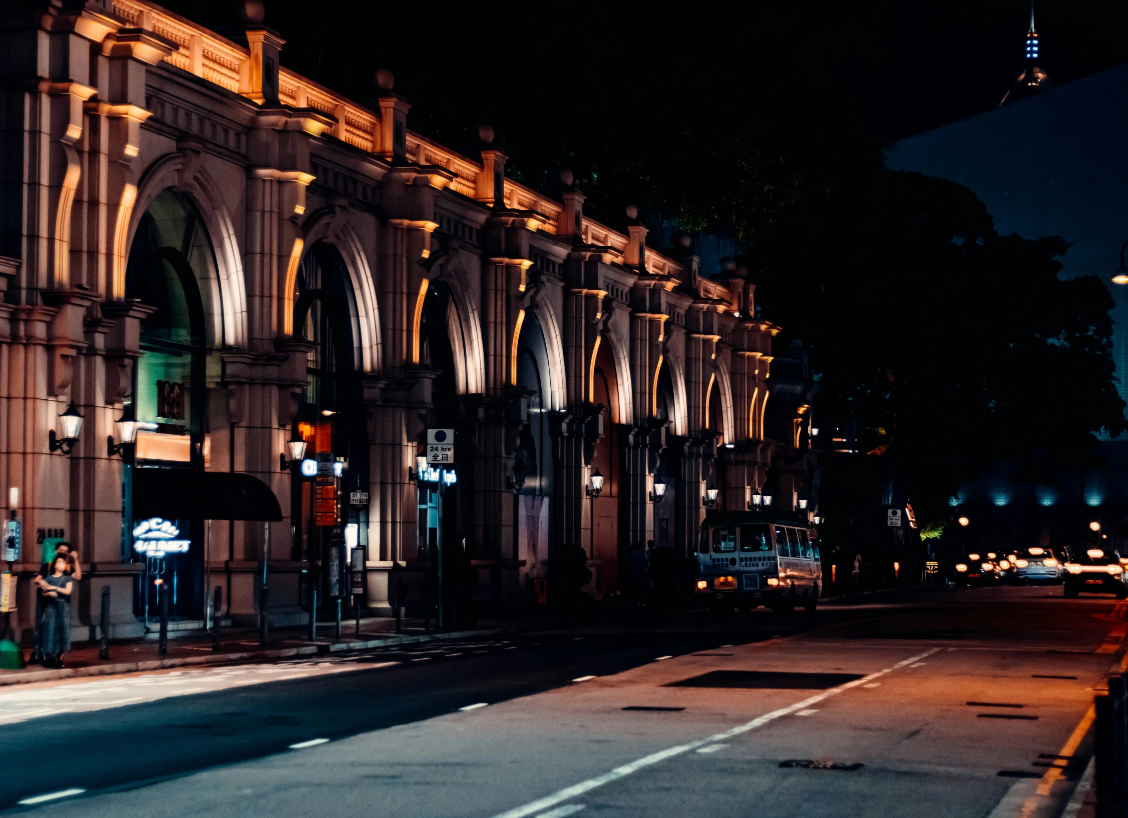 an empty street with buildings lit up at night