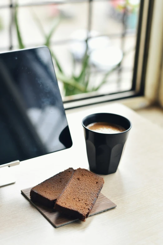 a cup of coffee is next to some brownies