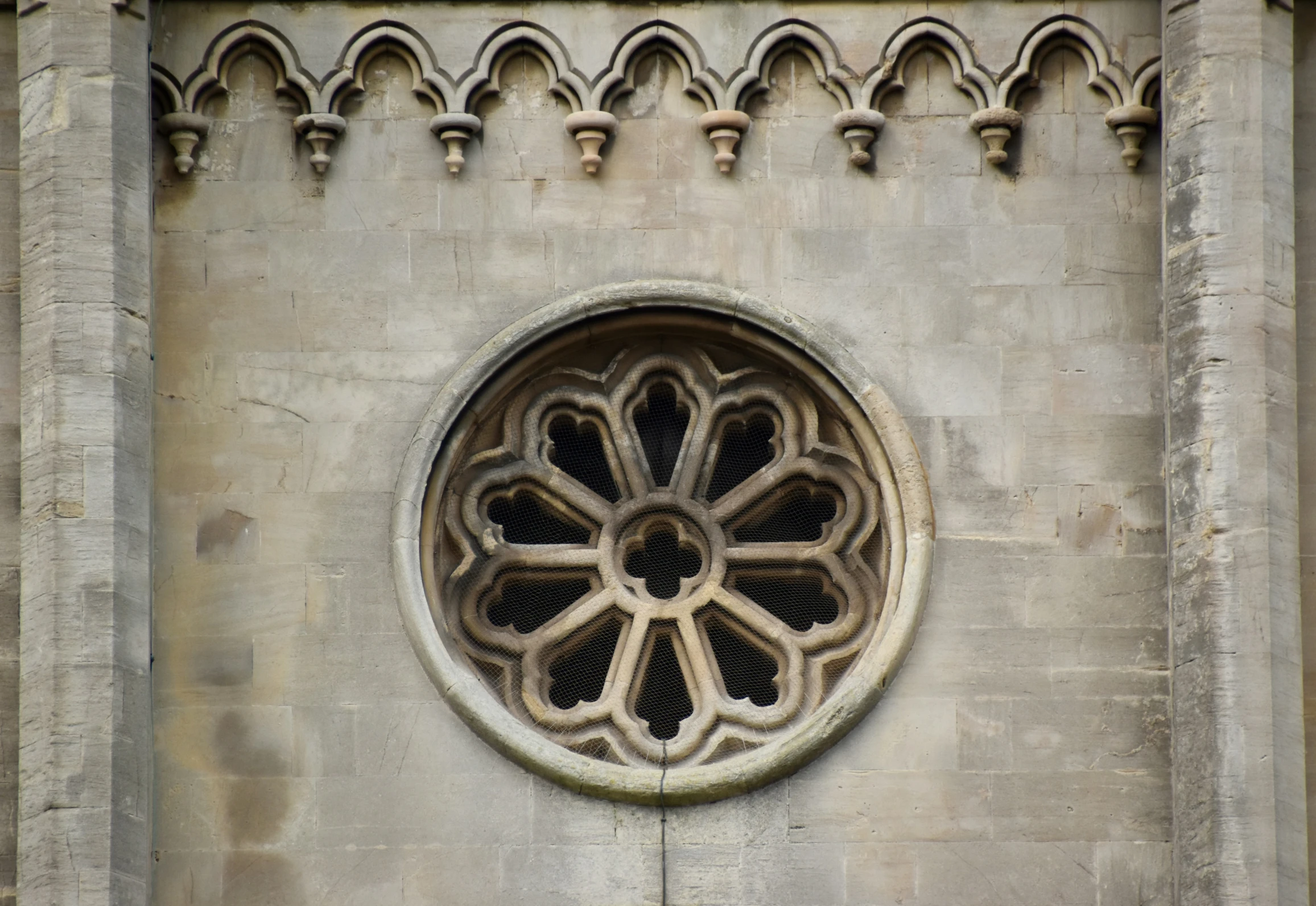 a stone building with an ornate window and circular window