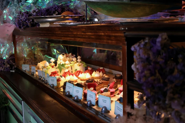 candles with flowers in them on display behind a counter