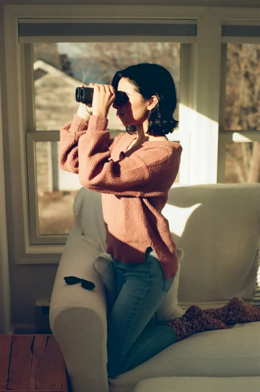 a woman sitting on a couch takes a pograph