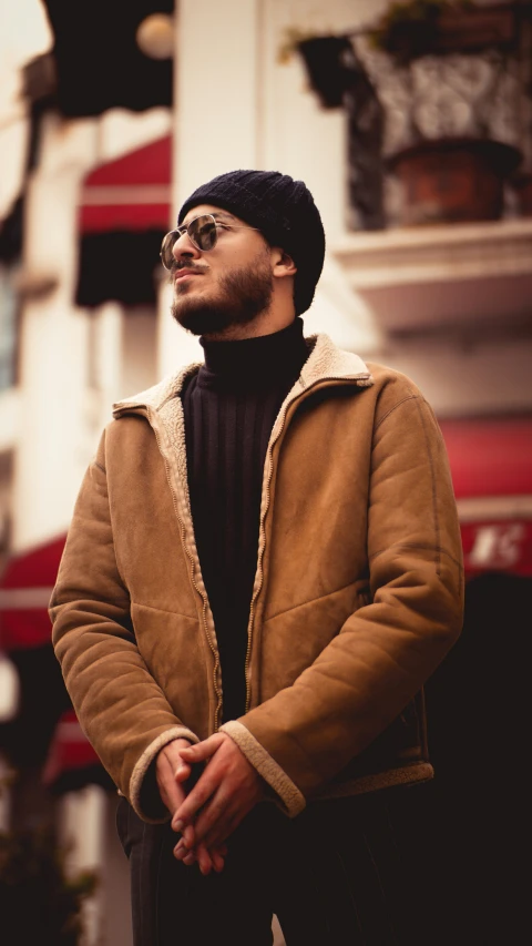 a man wearing a brown coat and black hat